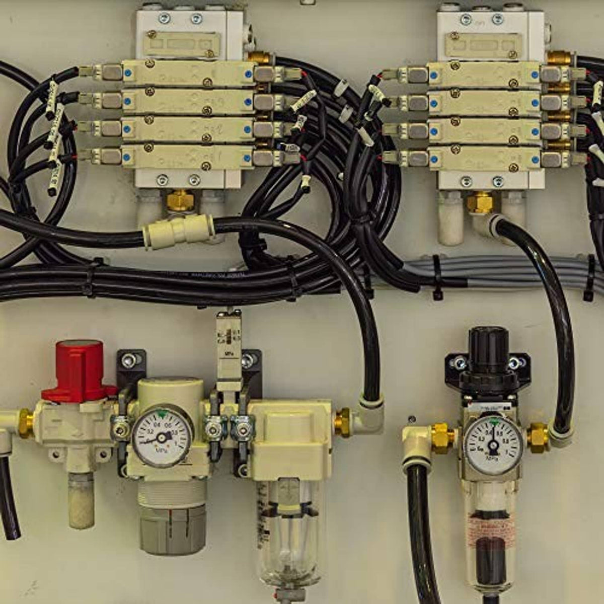 Brass hose barb fittings on a pneumatic control panel with hoses and valves