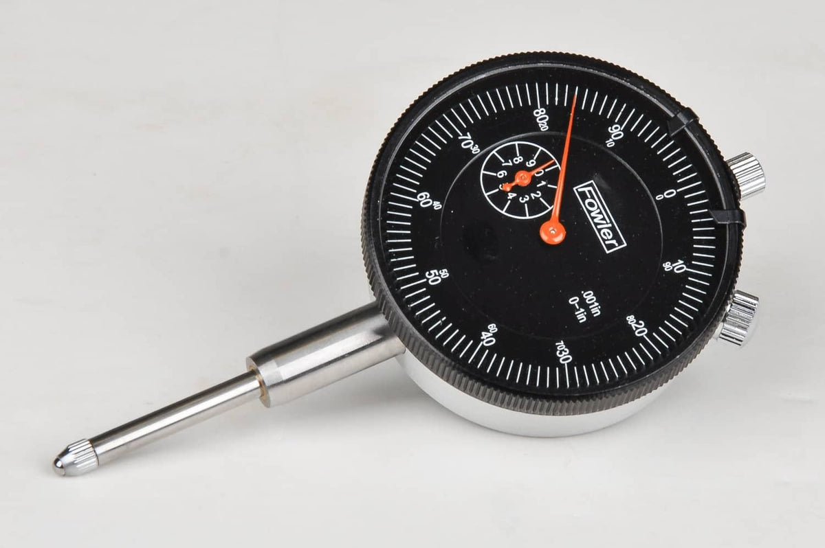 Dial indicator gauge with black bezel, orange pointer, and extendable probe