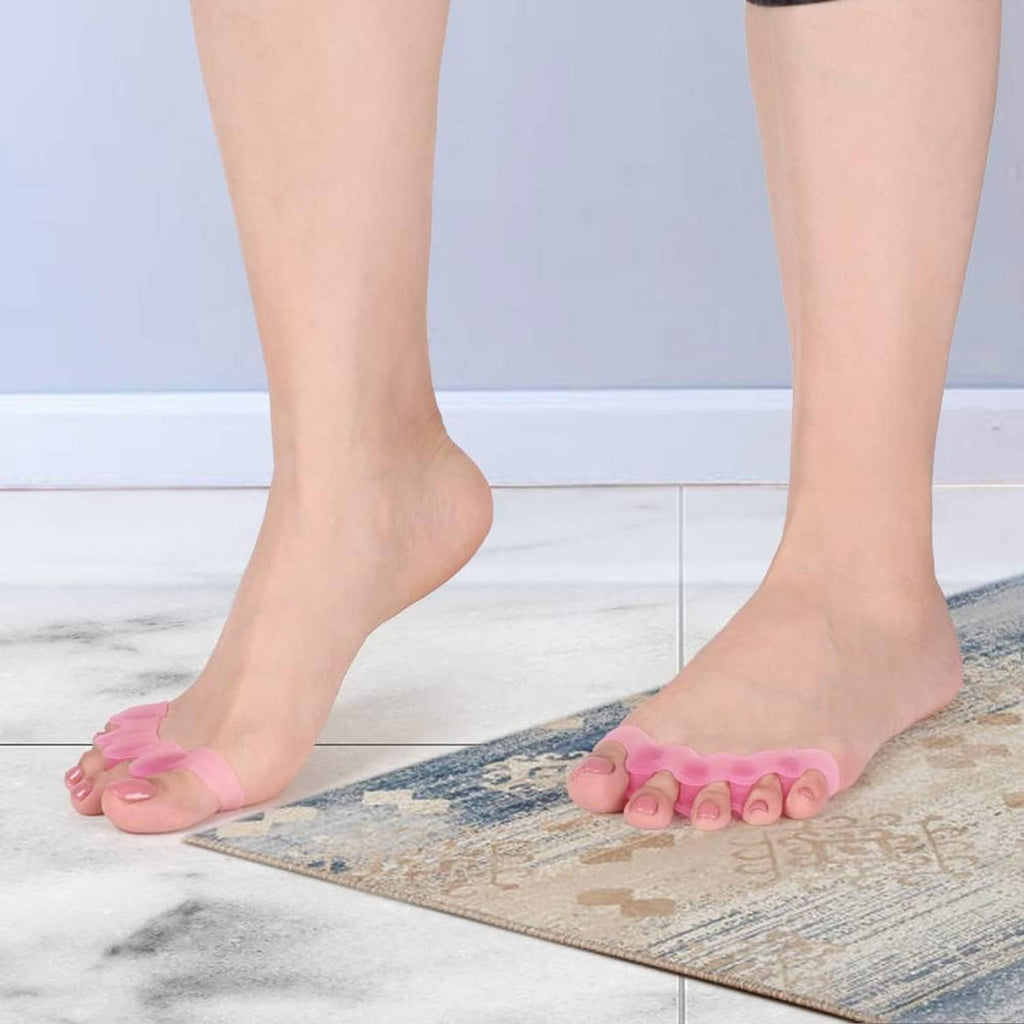 Pink toe separator spacer worn on feet with five toe loops