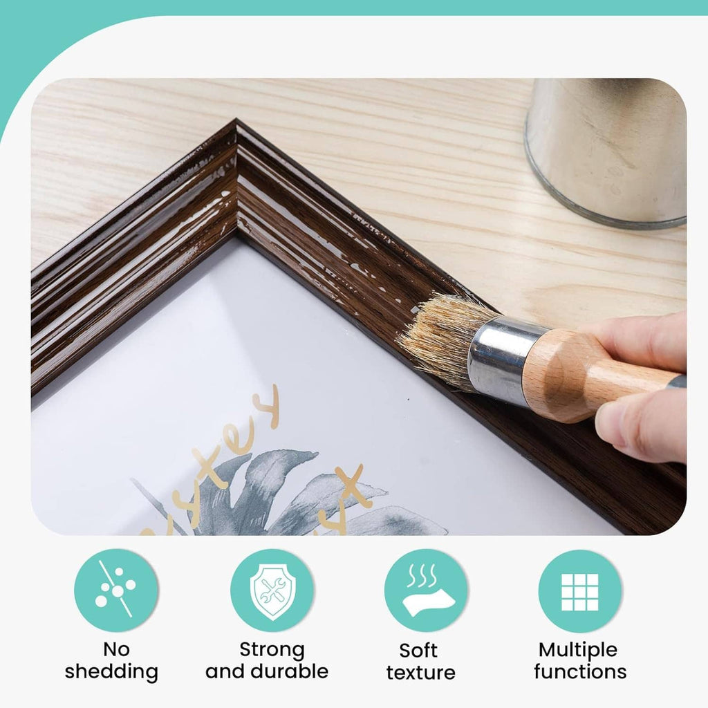 Small wax paint brush painting a wooden frame corner, light wood handle and beige bristles