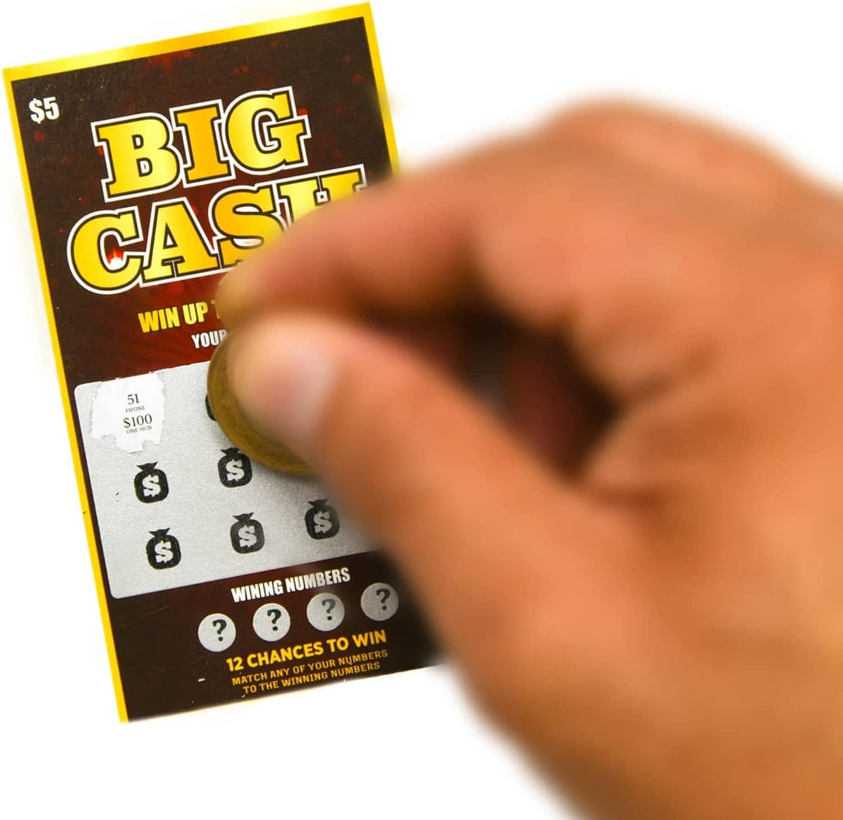 Hand scratching a dark Big Cash scratch-off lottery ticket with visible numbers and symbols