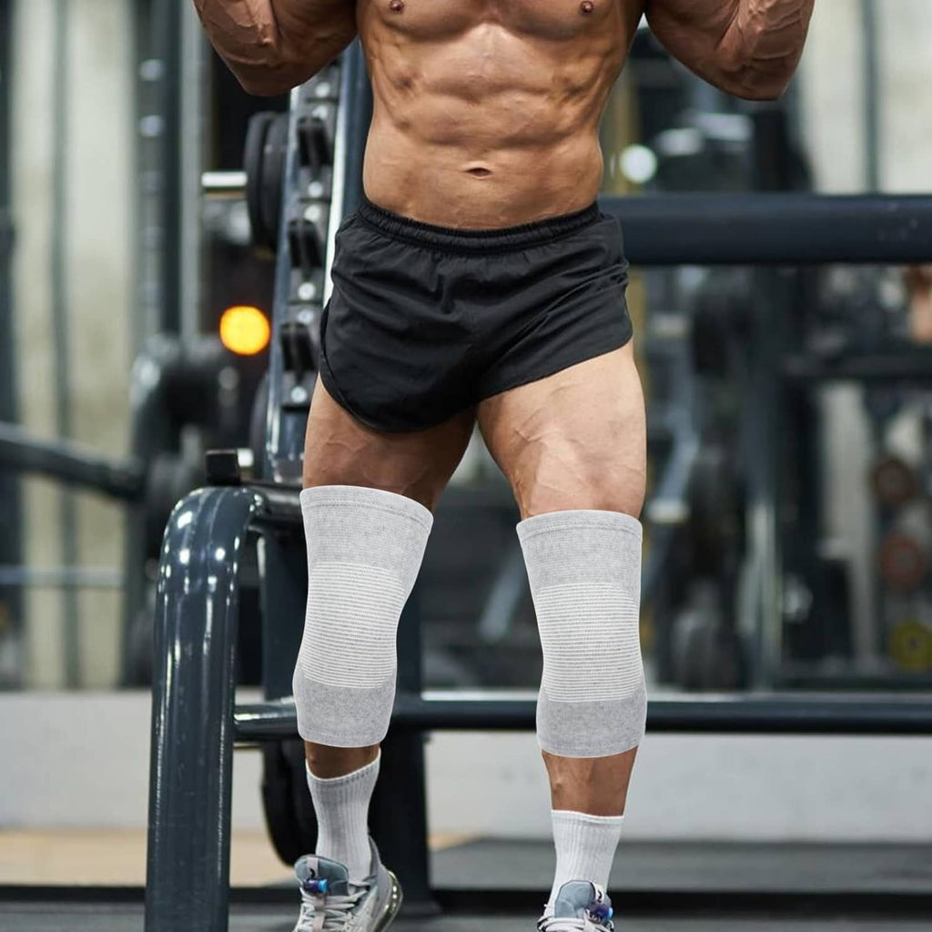 Gray knee sleeves worn on standing person with athletic calf support