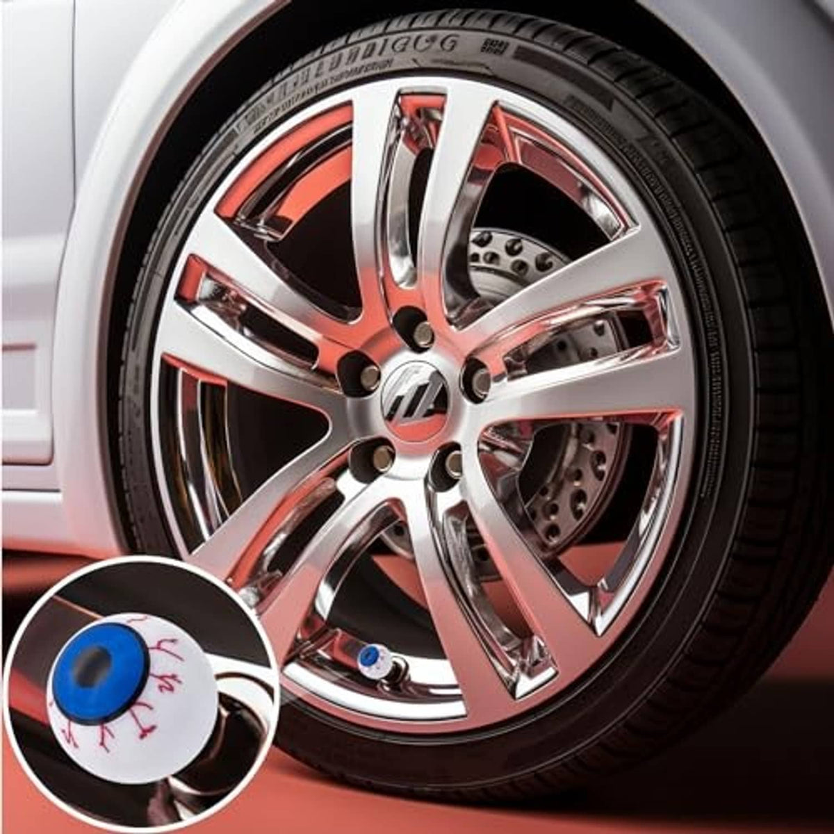 Eyeball tire valve stem cap installed on a car wheel, white with blue eye and red veins