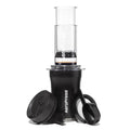 Black AeroPress Go Plus portable coffee maker kit with clear brewing chamber and lid.