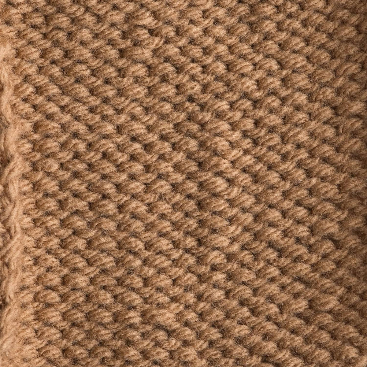 Close-up of warm tan/brown knit fabric with tight textured stitch pattern.