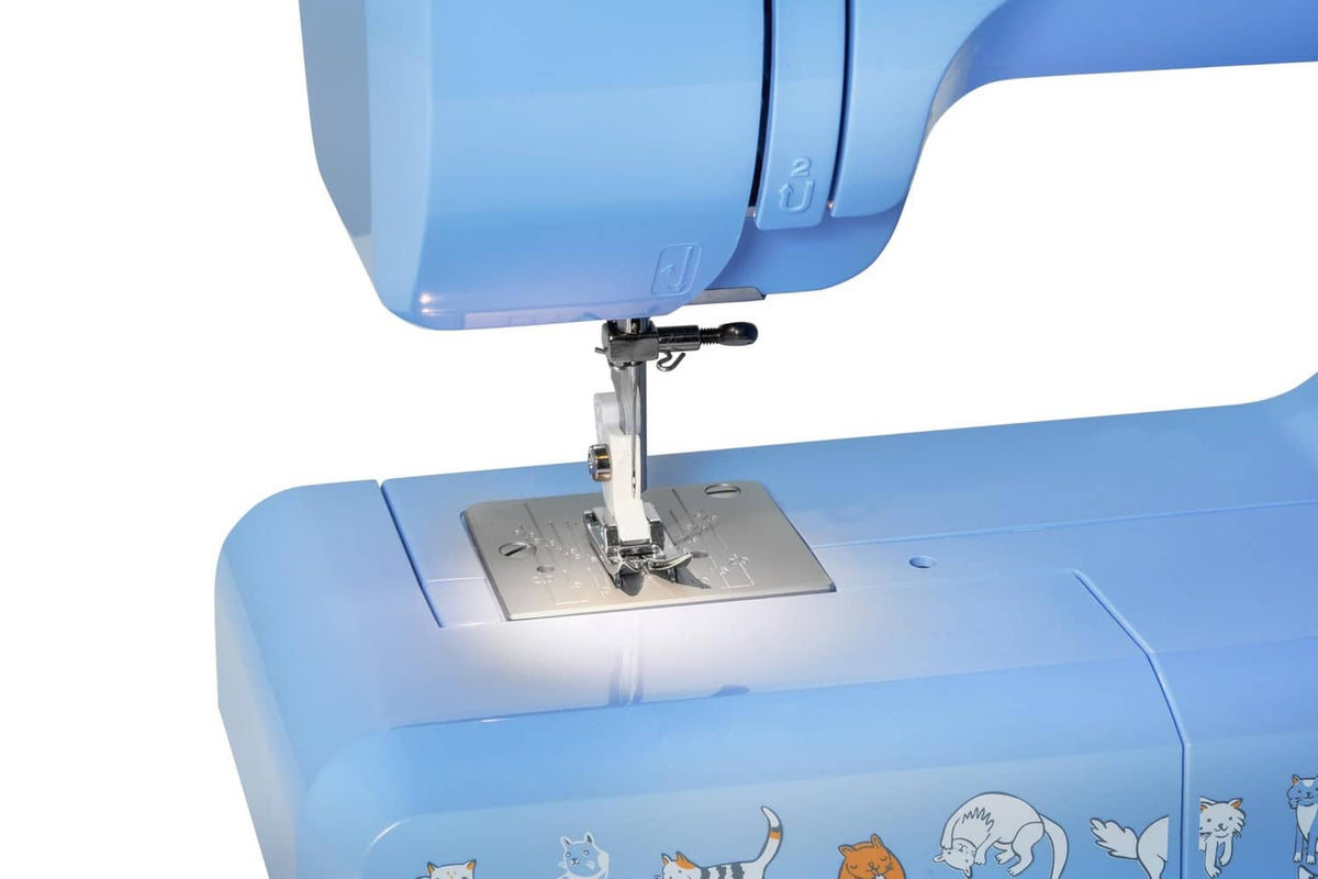Blue Janome sewing machine close-up of needle and presser foot on metal plate
