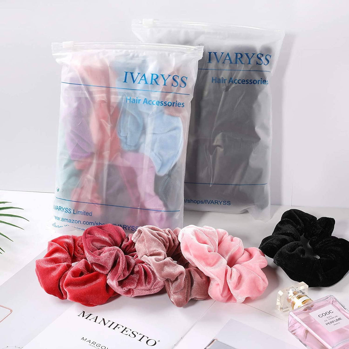 Assorted velvet scrunchies in black, pink, and light blue in a clear bag