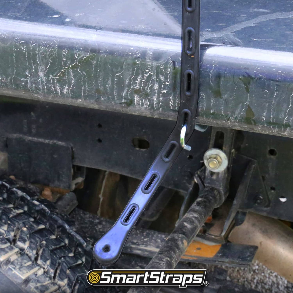 Close-up of black adjustable rubber tarp strap wrapped around a metal bar