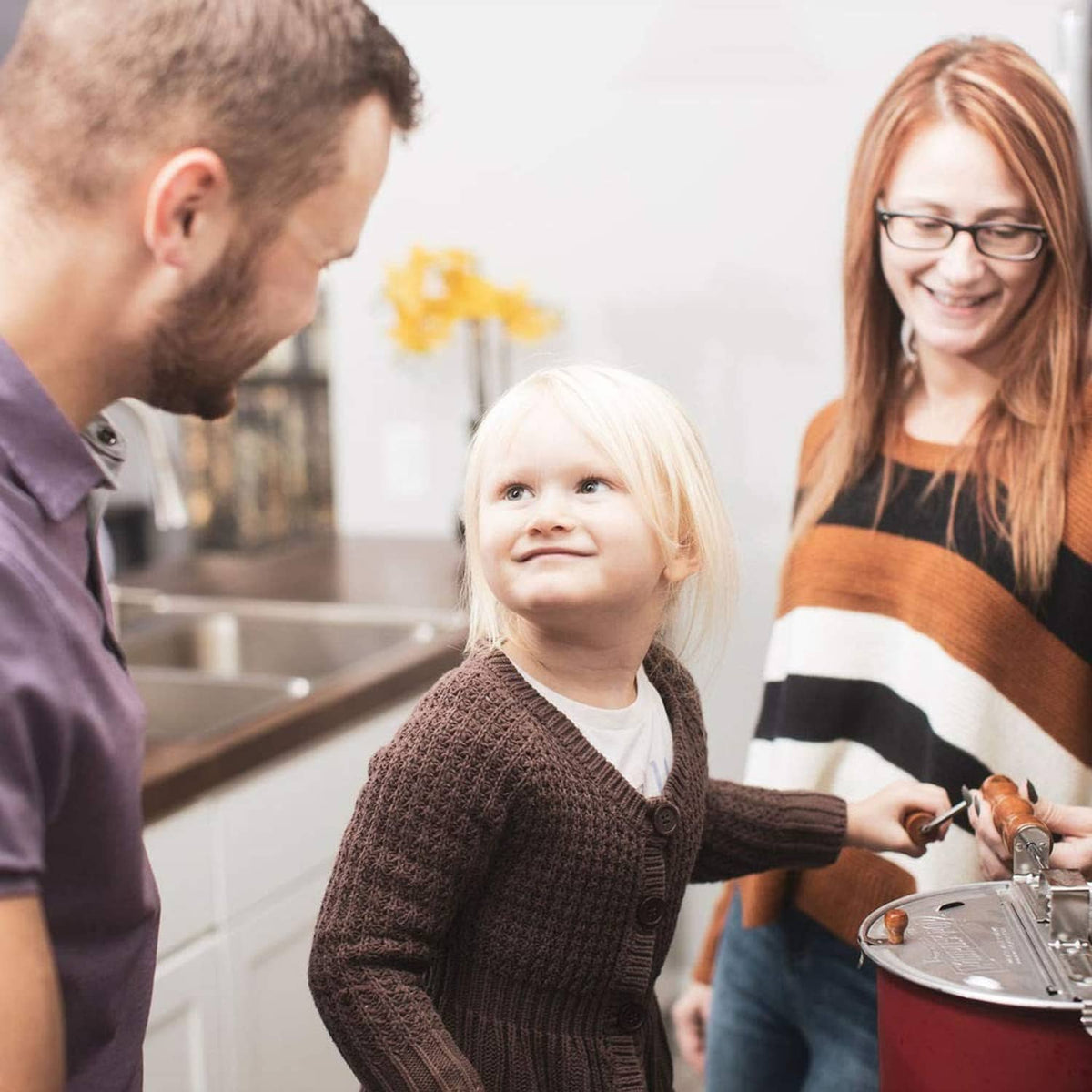 Family preparing popcorn with a bag of kernels on the countertop