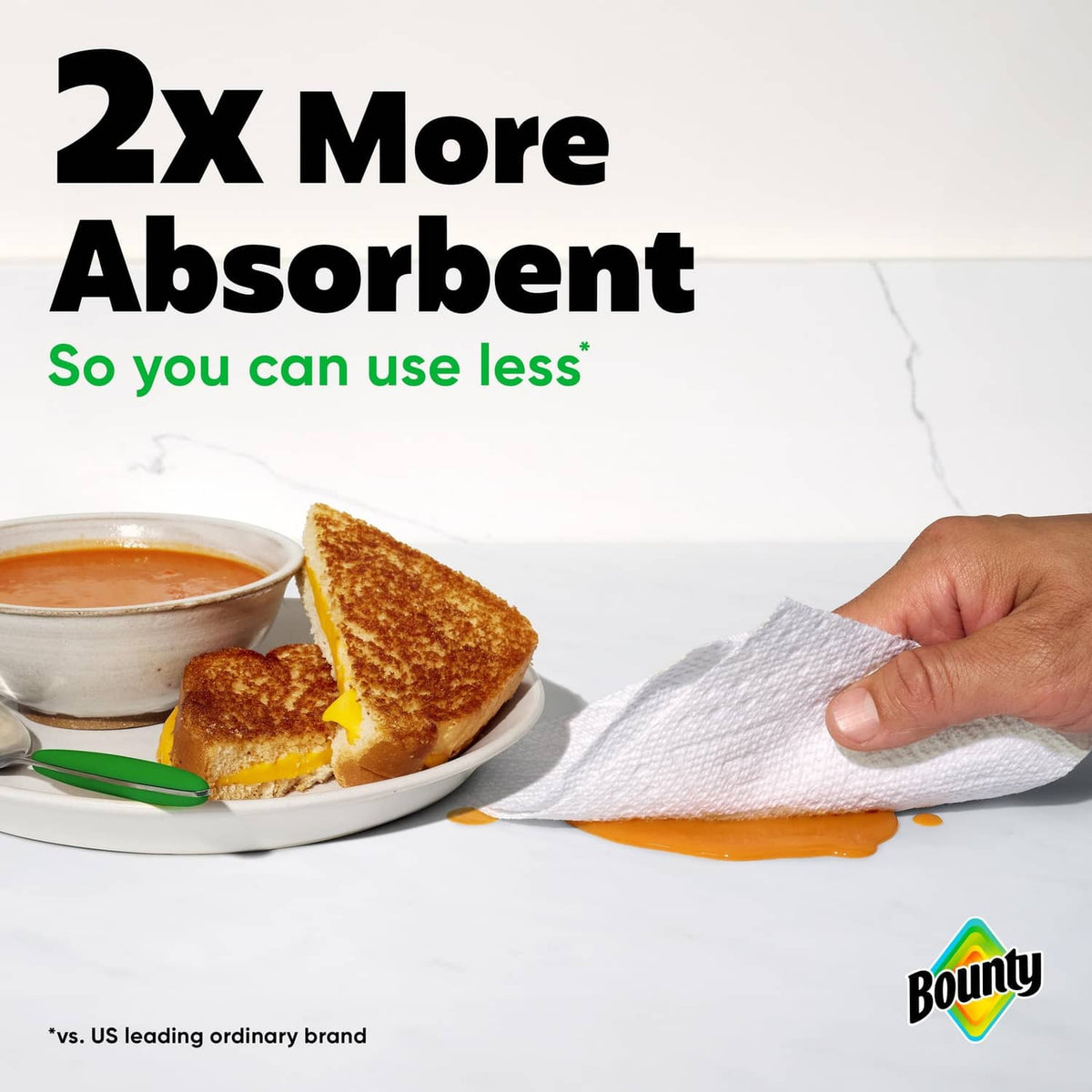 White Bounty paper towel sheet held above a stain, absorbent textured surface