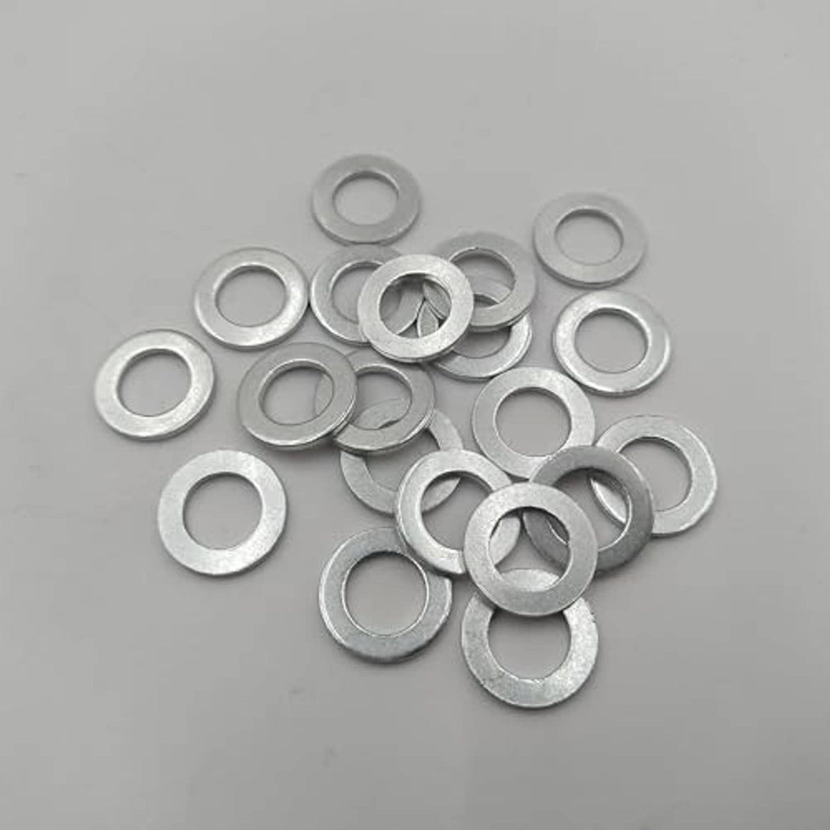 Silver engine oil drain plug crush washers, loose pile, flat round rings