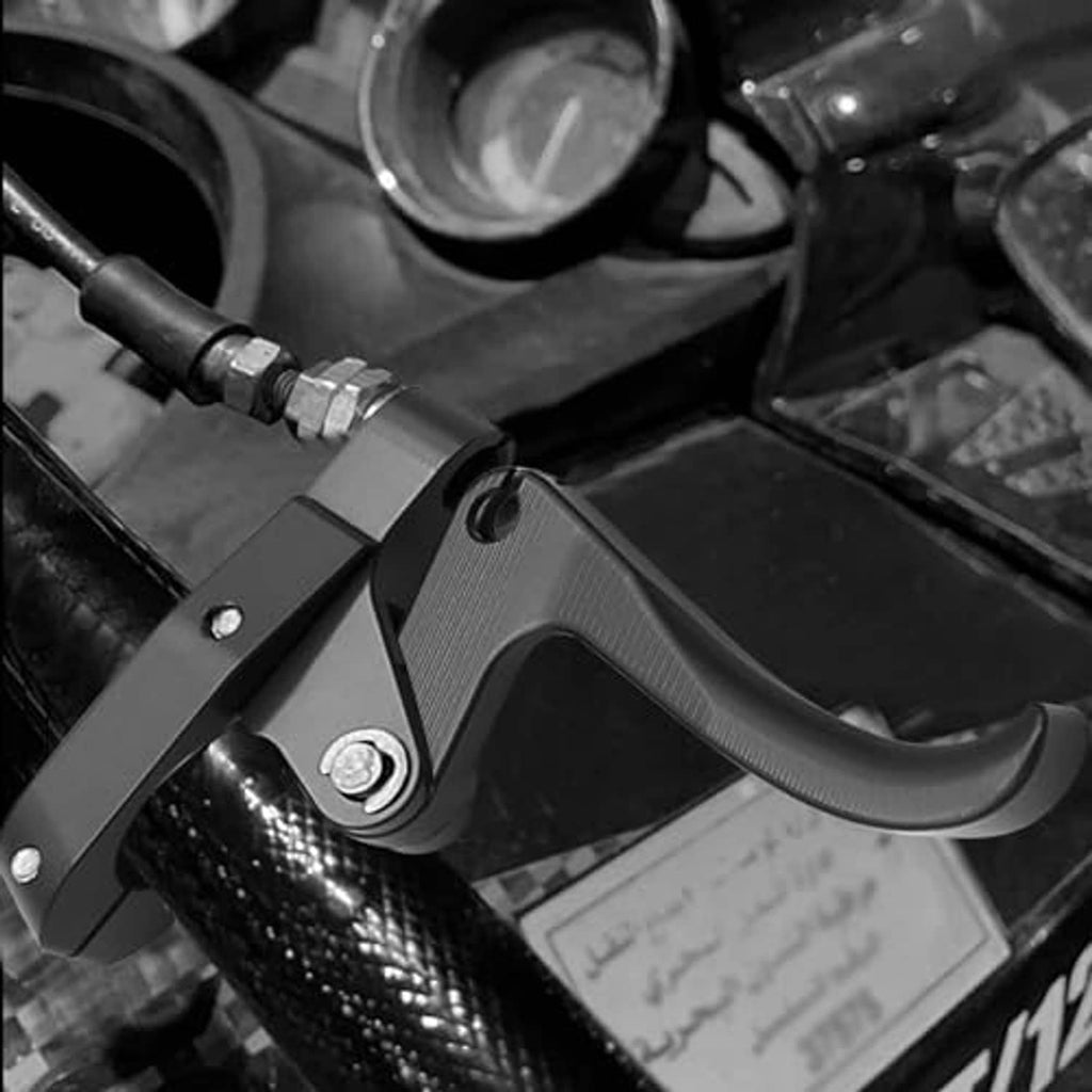 Black CNC finger throttle clutch lever close-up on motorcycle handlebar, textured lever
