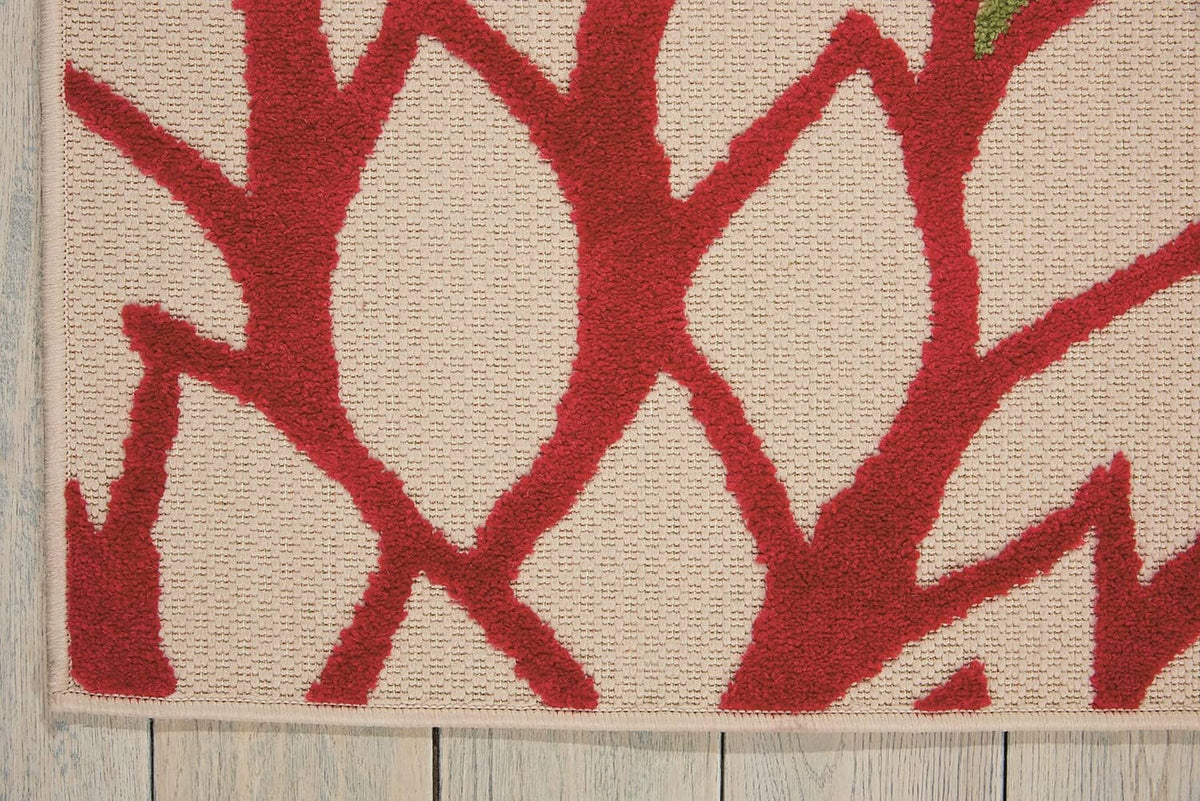Tropical area rug close-up of red vine-like pattern on light background