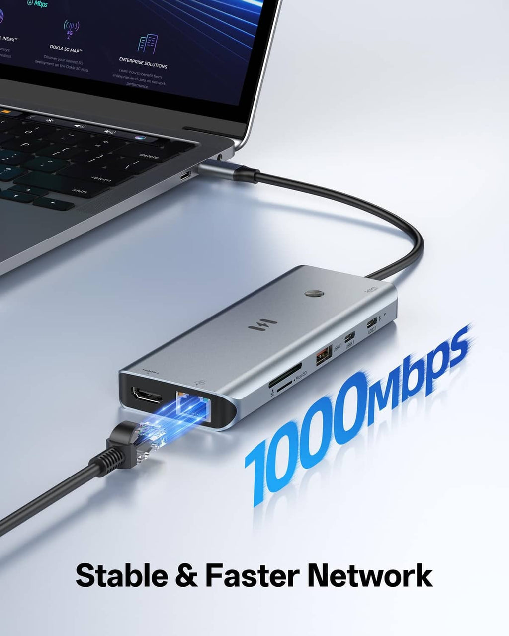 Space gray USB-C docking station with Ethernet and USB ports connected to a laptop