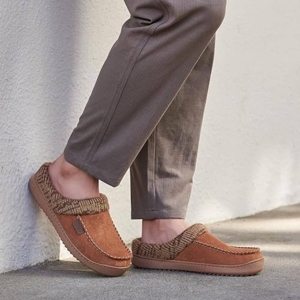 Brown moccasin slipper clogs worn with gray pants, knit cuff and stitched suede trim