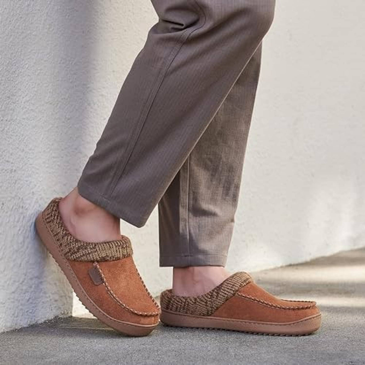 Brown moccasin slipper clogs worn with gray pants, knit cuff and stitched suede trim