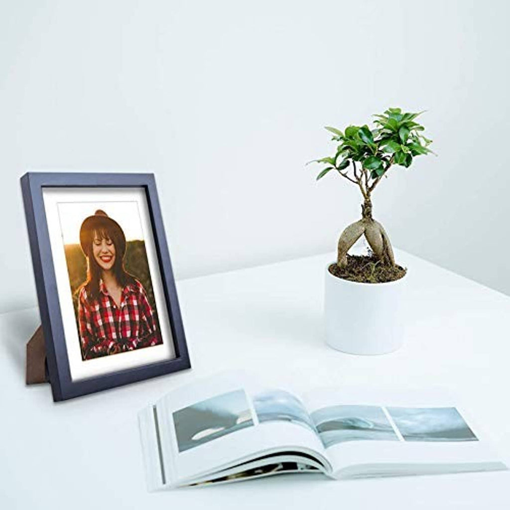 Blue-gray solid wood picture frame with white mat, holding a portrait photo