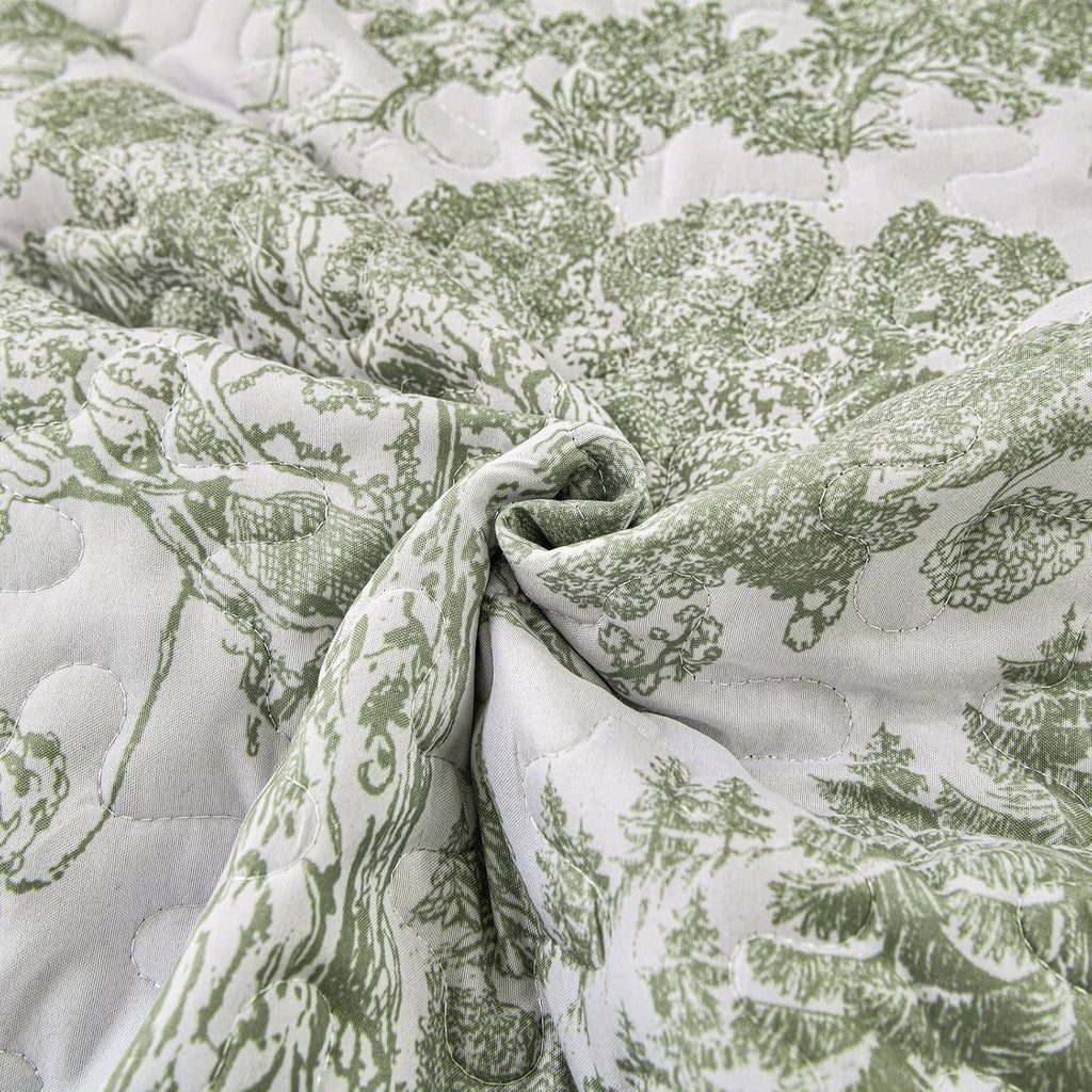 Sage green and white botanical print quilt fabric with quilted texture close-up