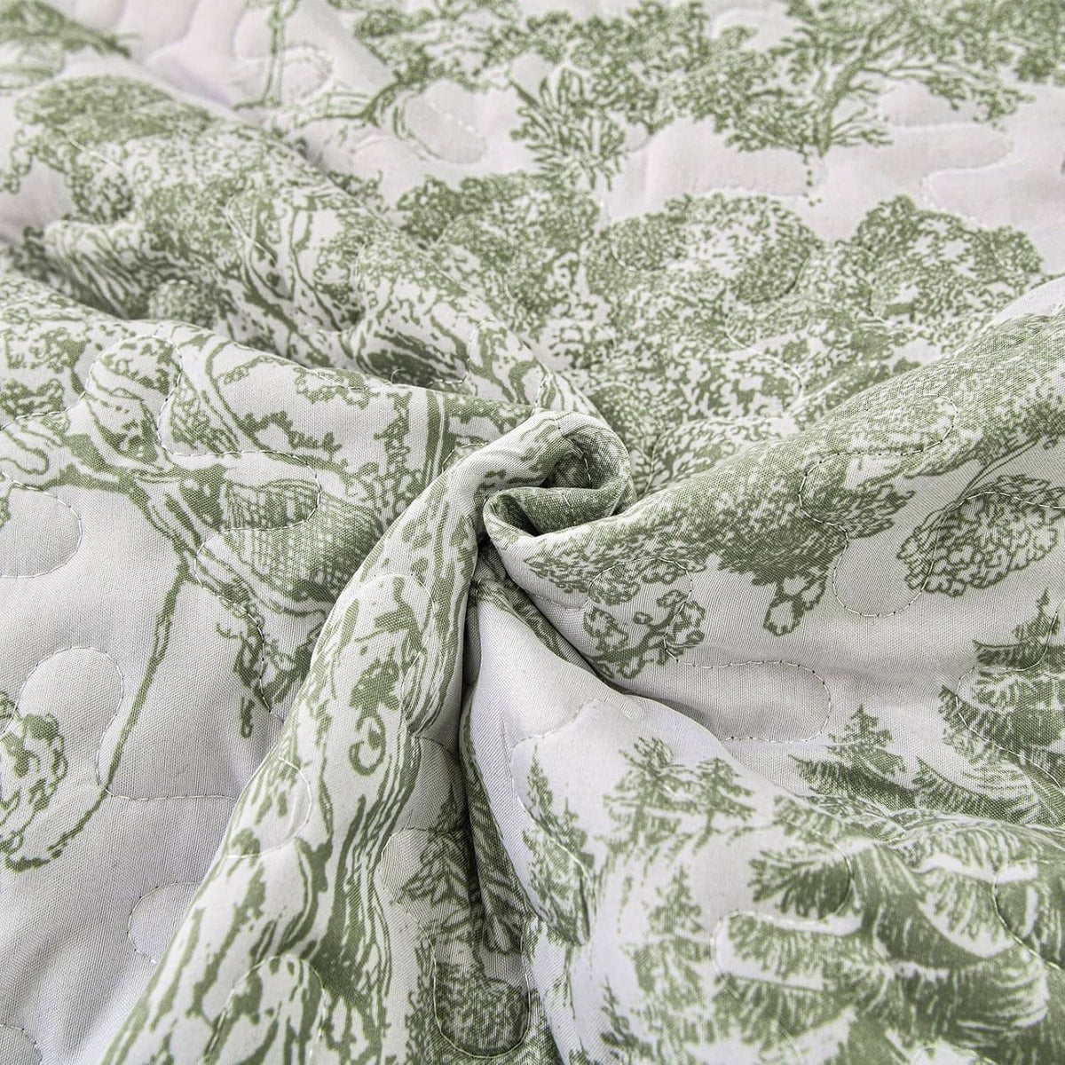 Sage green and white botanical print quilt fabric with quilted texture close-up