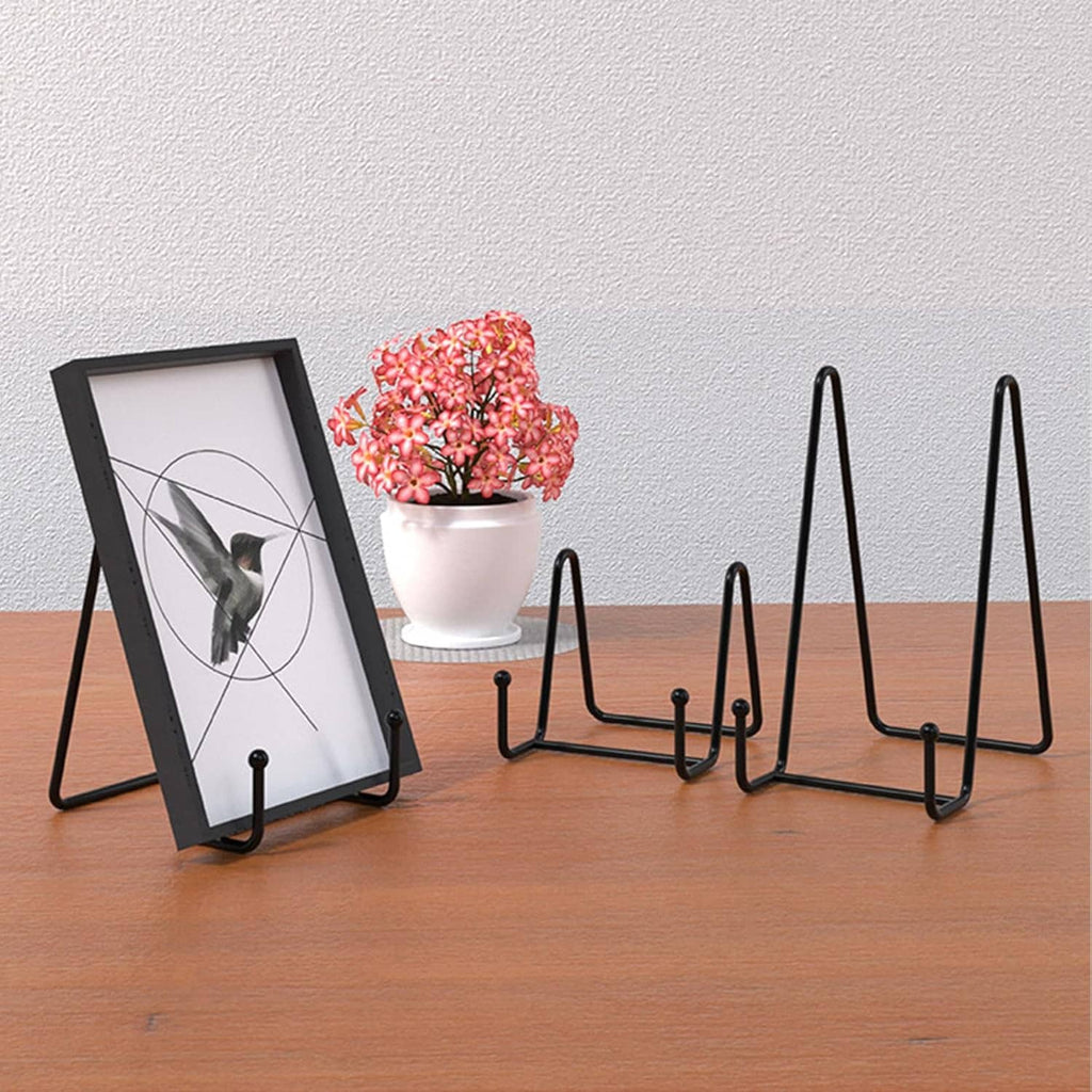 Black metal plate stands holding framed art and a small plate on a tabletop