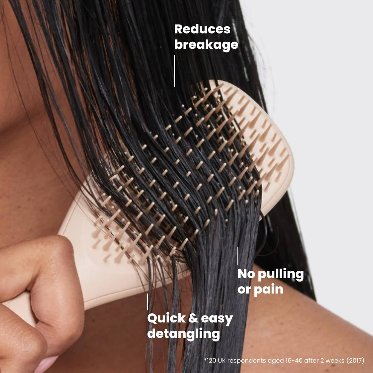 Cream detangling brush held against dark hair for quick, gentle detangling