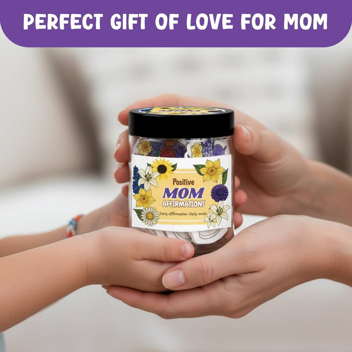 Floral mom affirmation jar with black lid held by hands, label with Positive MOM
