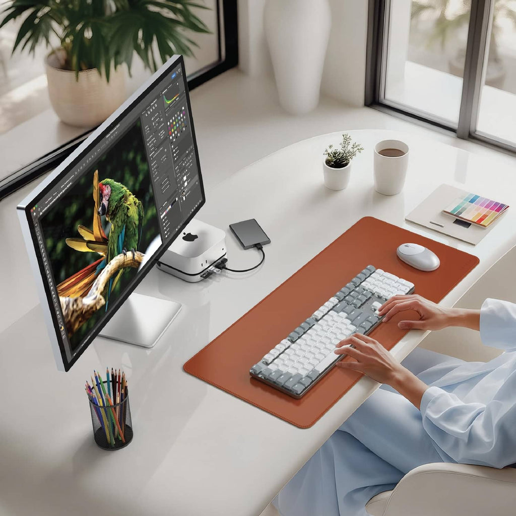 Silver docking hub on desk beside monitor, keyboard, and pointing accessories