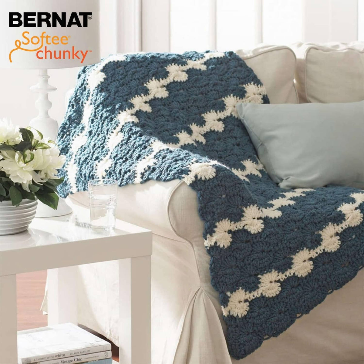 Dark blue and cream star-pattern chunky knit throw blanket on a sofa