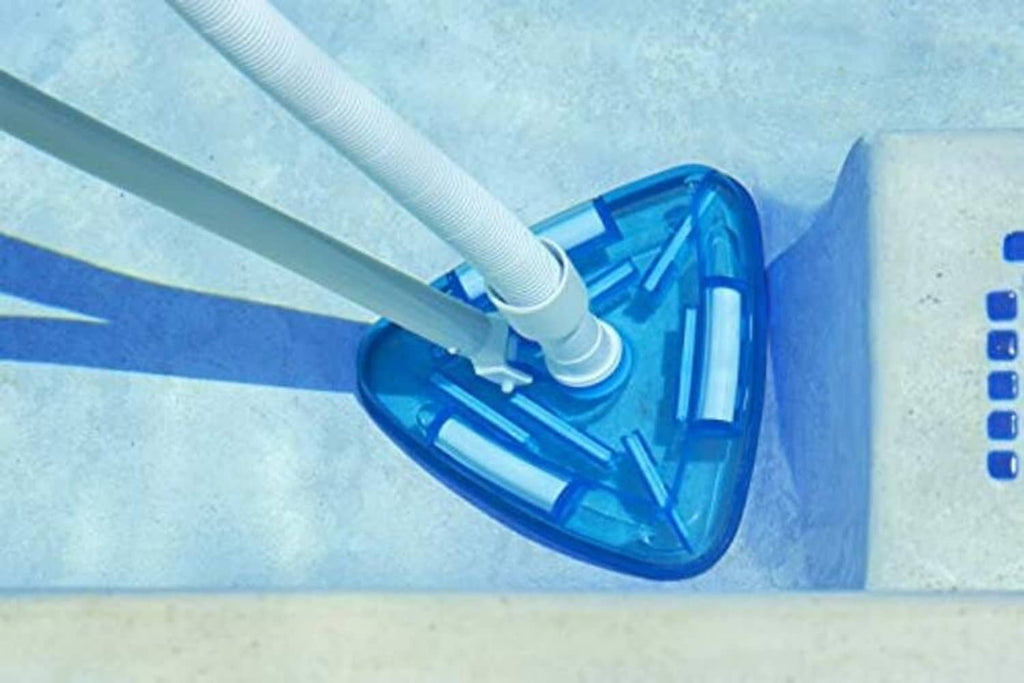 Triangle pool vacuum head on pool wall with white hose and clear blue liner