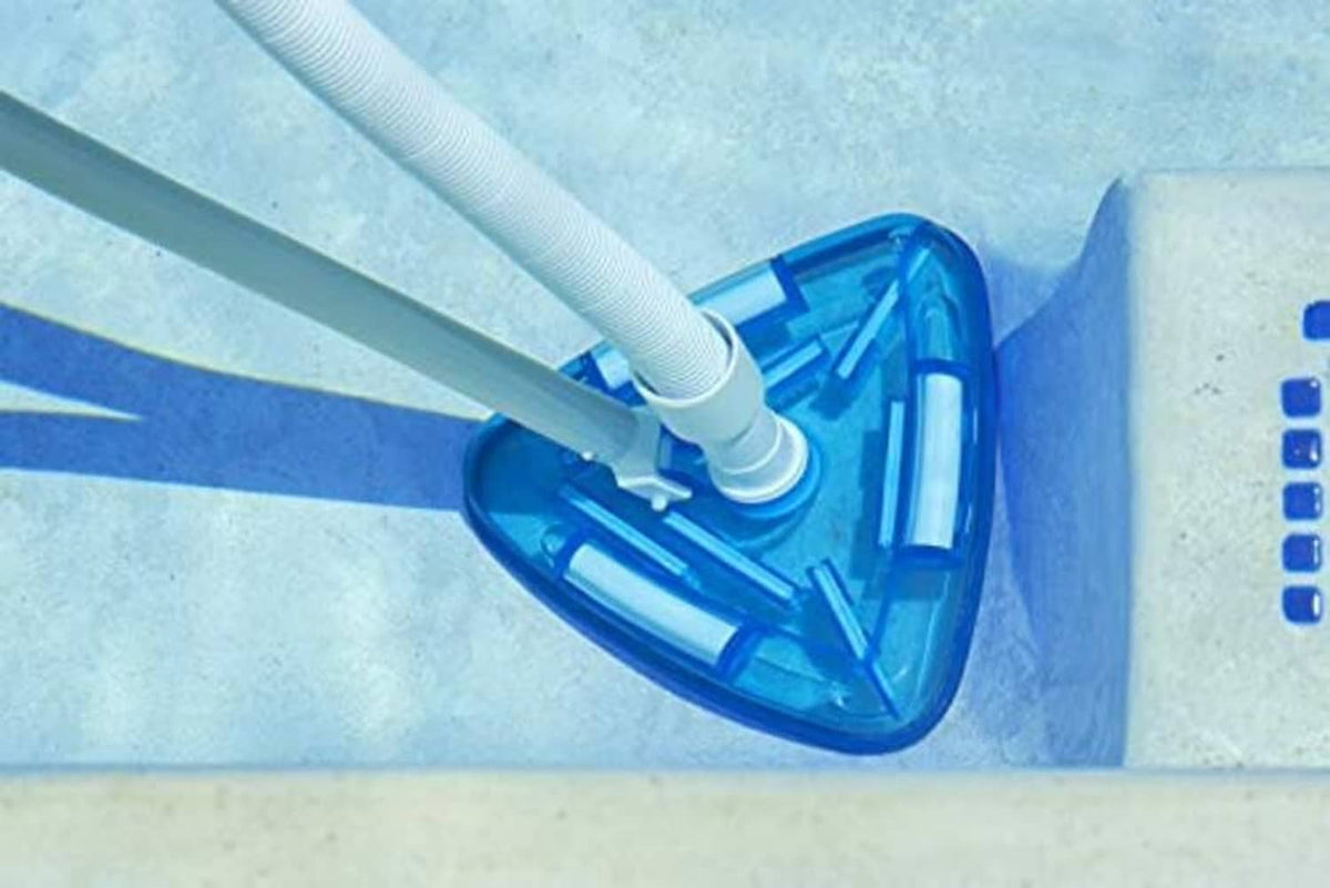 Triangle pool vacuum head on pool wall with white hose and clear blue liner
