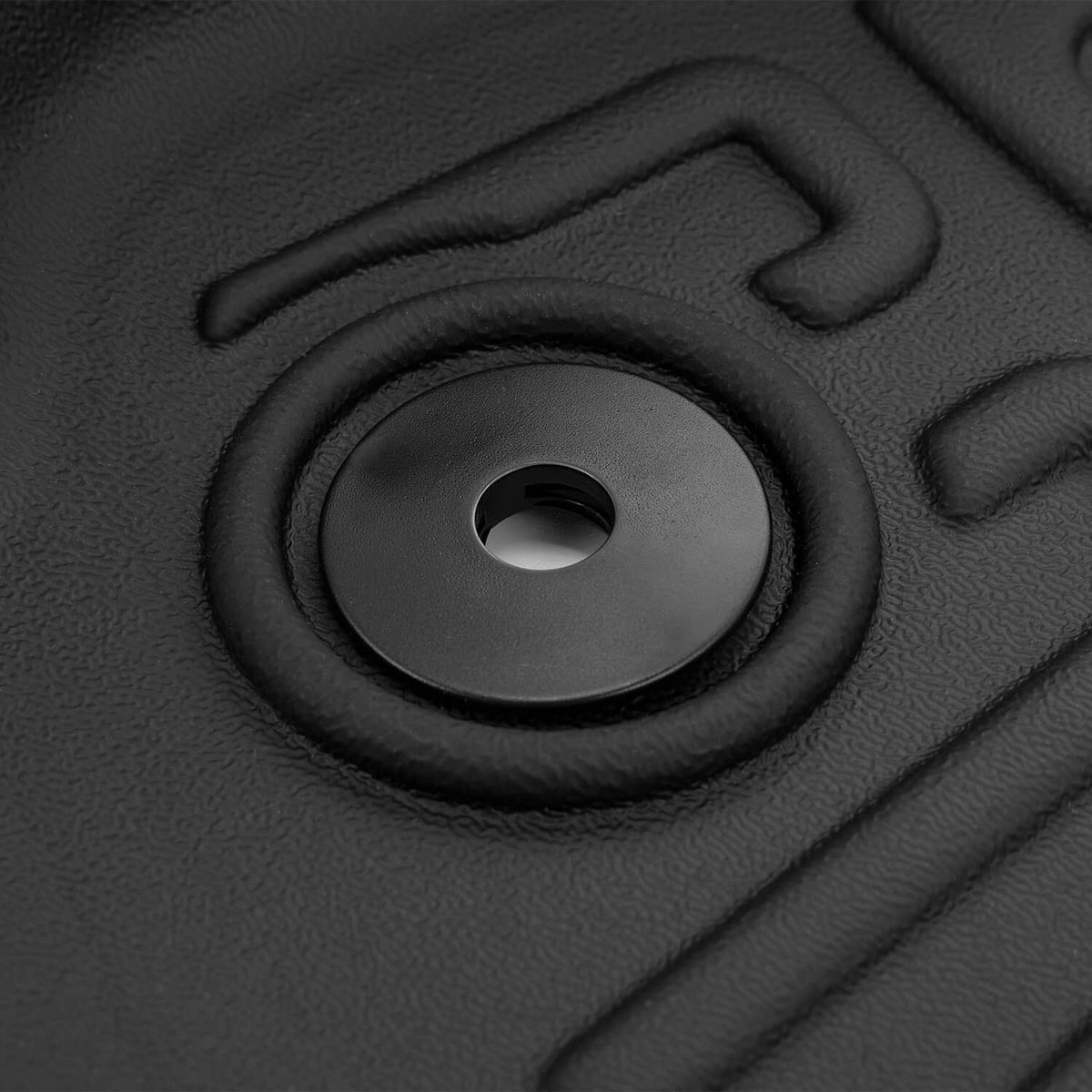 Black molded floor mat with circular grommet/drain hole and surrounding grip ring