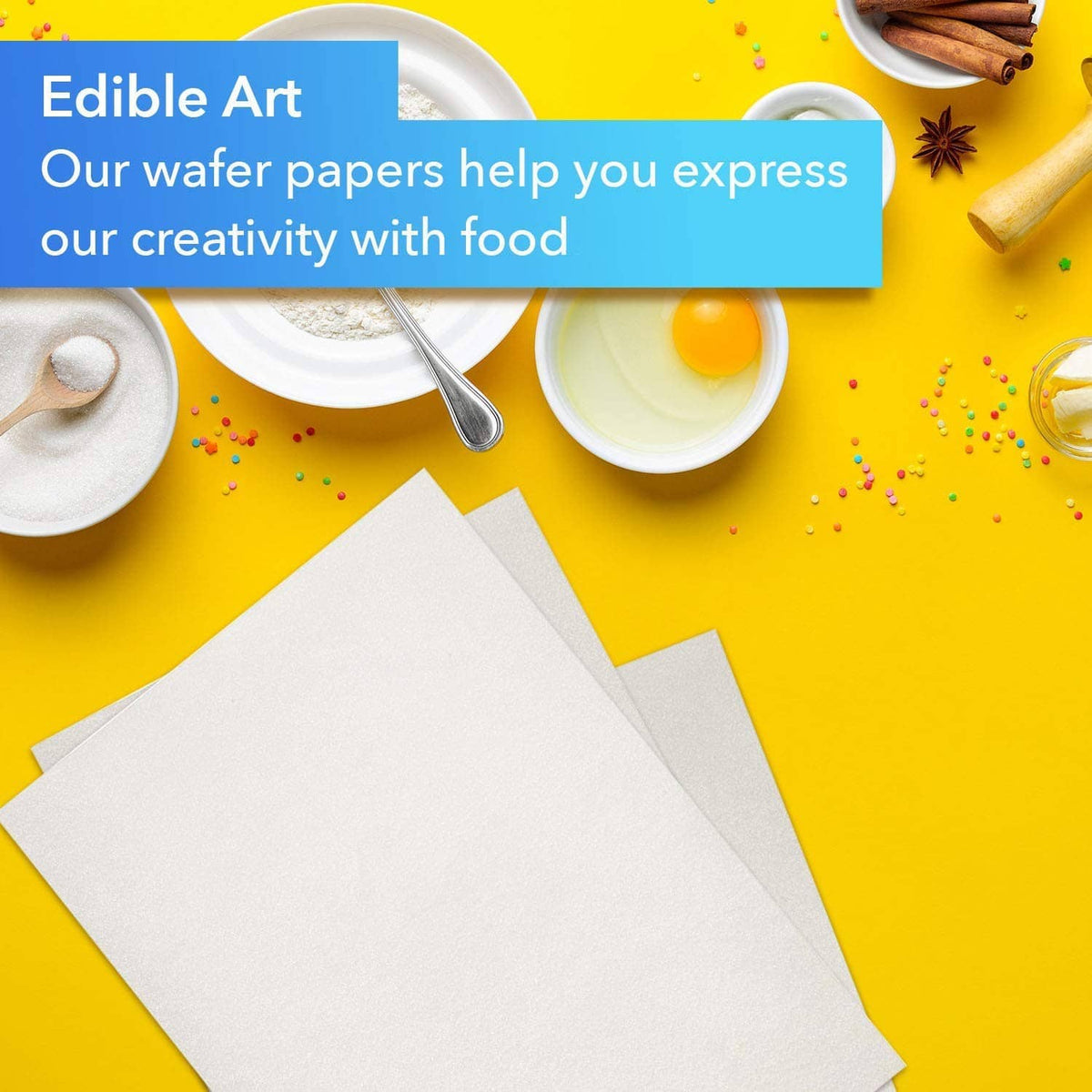 Rectangular edible wafer paper sheets on yellow table with baking tools and sprinkles