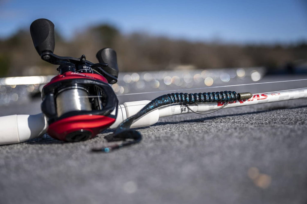 Soft plastic fishing worm on a fishing rod, black with blue flecks