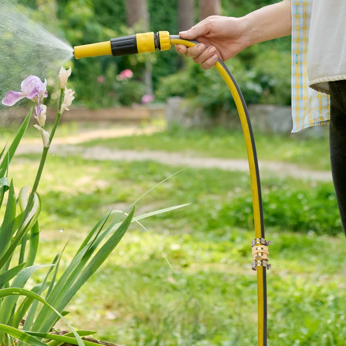 Gold brass garden hose repair connector with metal clamp on yellow hose