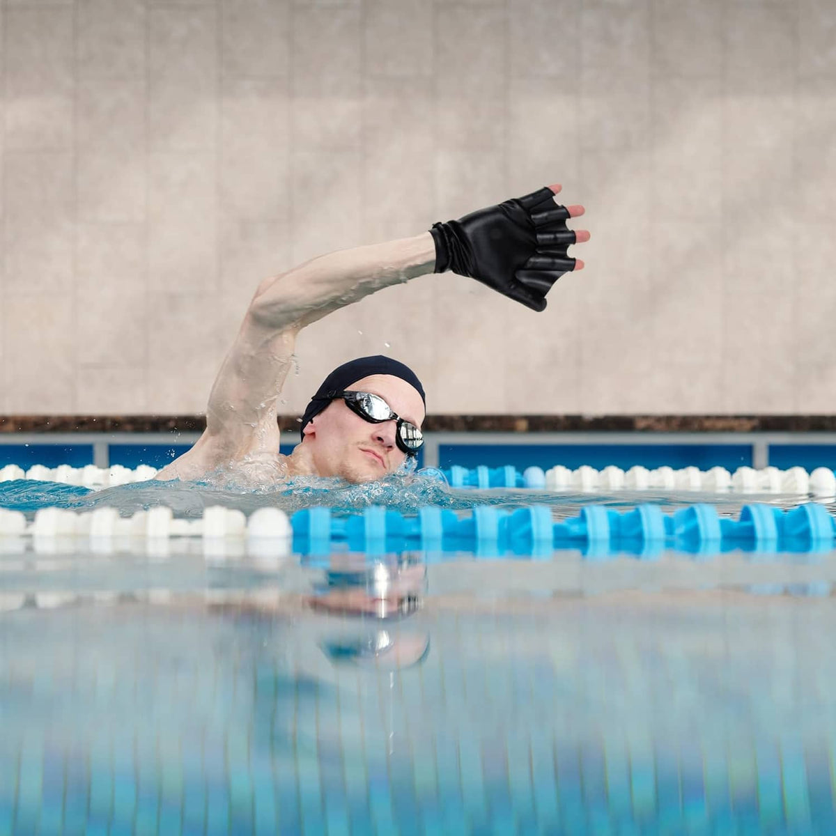 Black aquatic resistance gloves worn by swimmer in pool