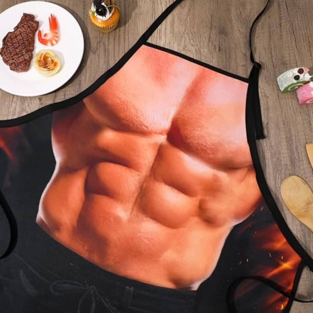 Black apron with close-up orange muscular torso graphic and fiery flame accents