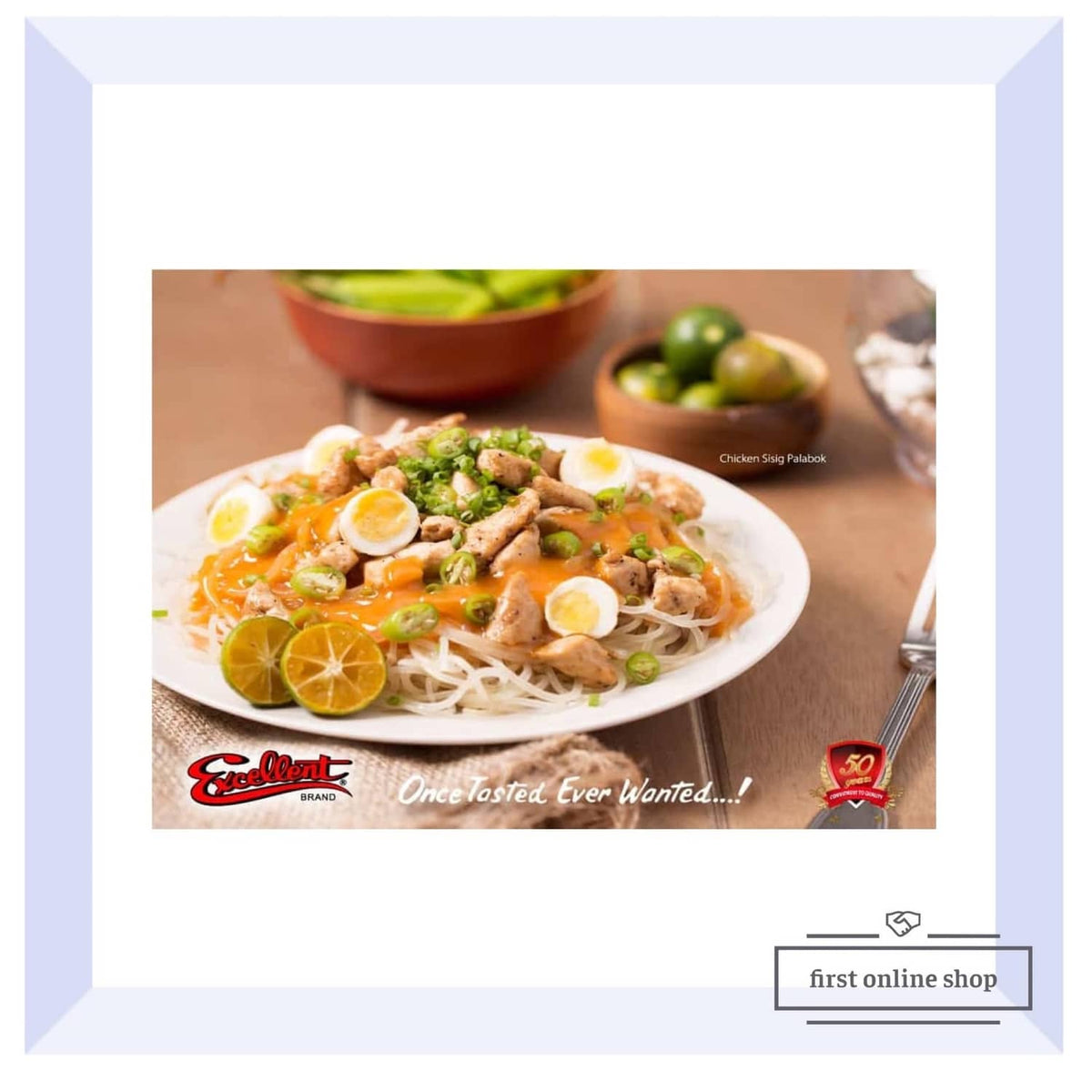 Bowl of pancit noodles with chicken, citrus slices, and herbs