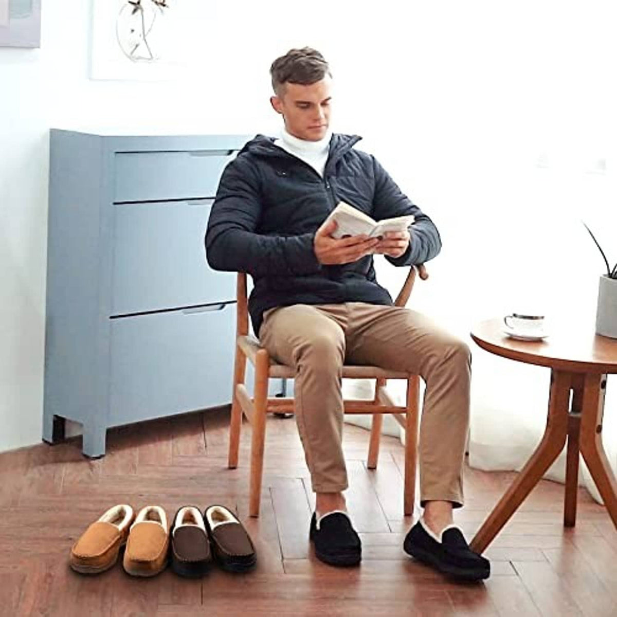 Men’s brown moccasin slippers with plush lining, worn with casual pants