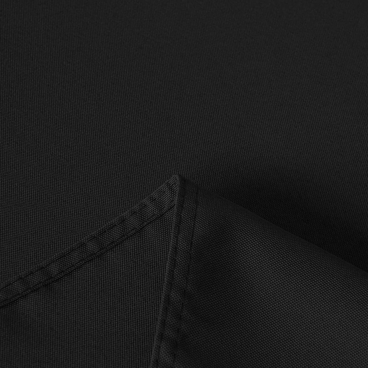 Dark tablecloth fabric with visible weave texture and stitched corner seam detail.