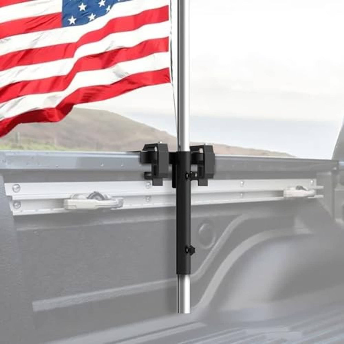 Black flag pole mount clamp secured to pickup bed side rail
