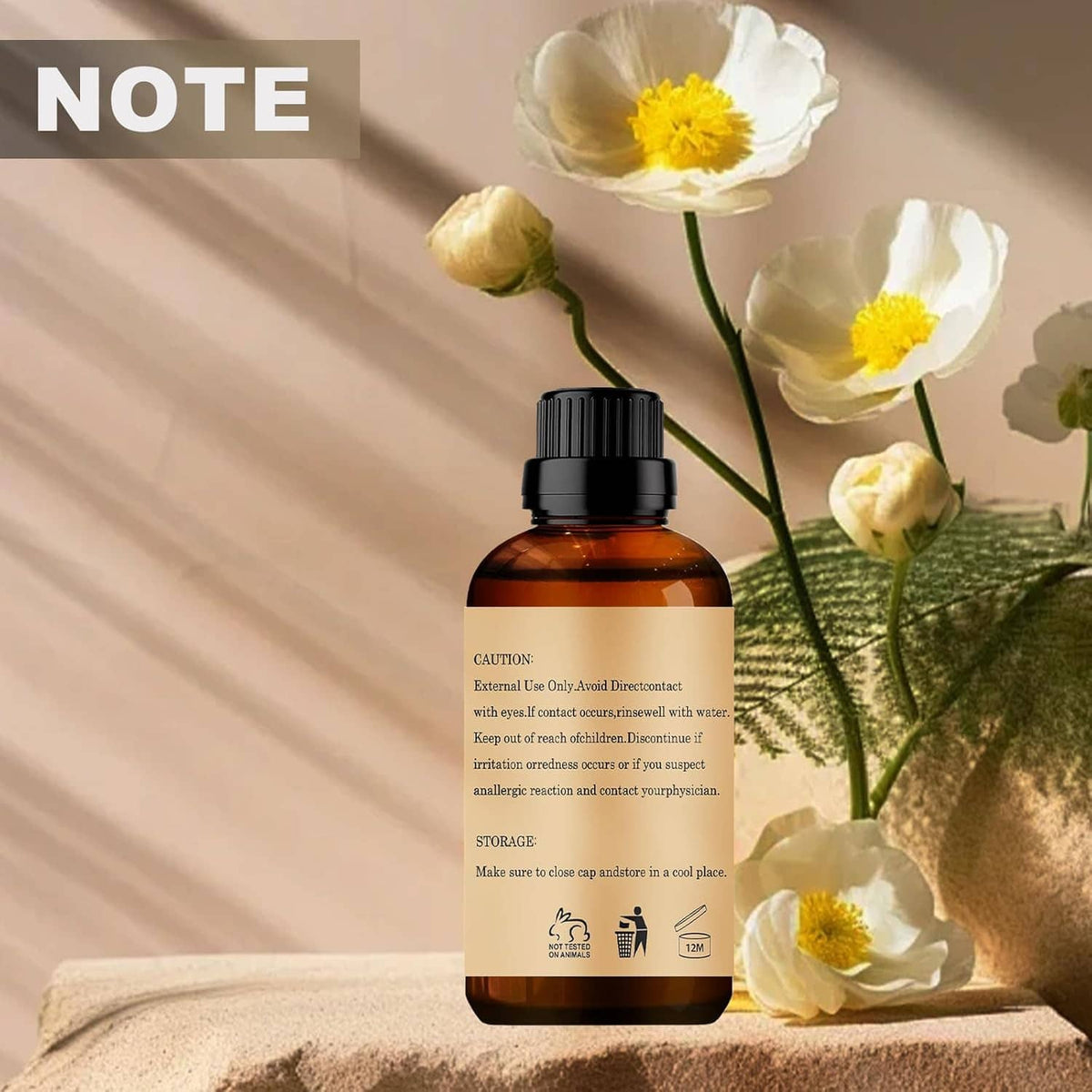Rose essential oil bottle with visible back label, black cap, and white flowers.
