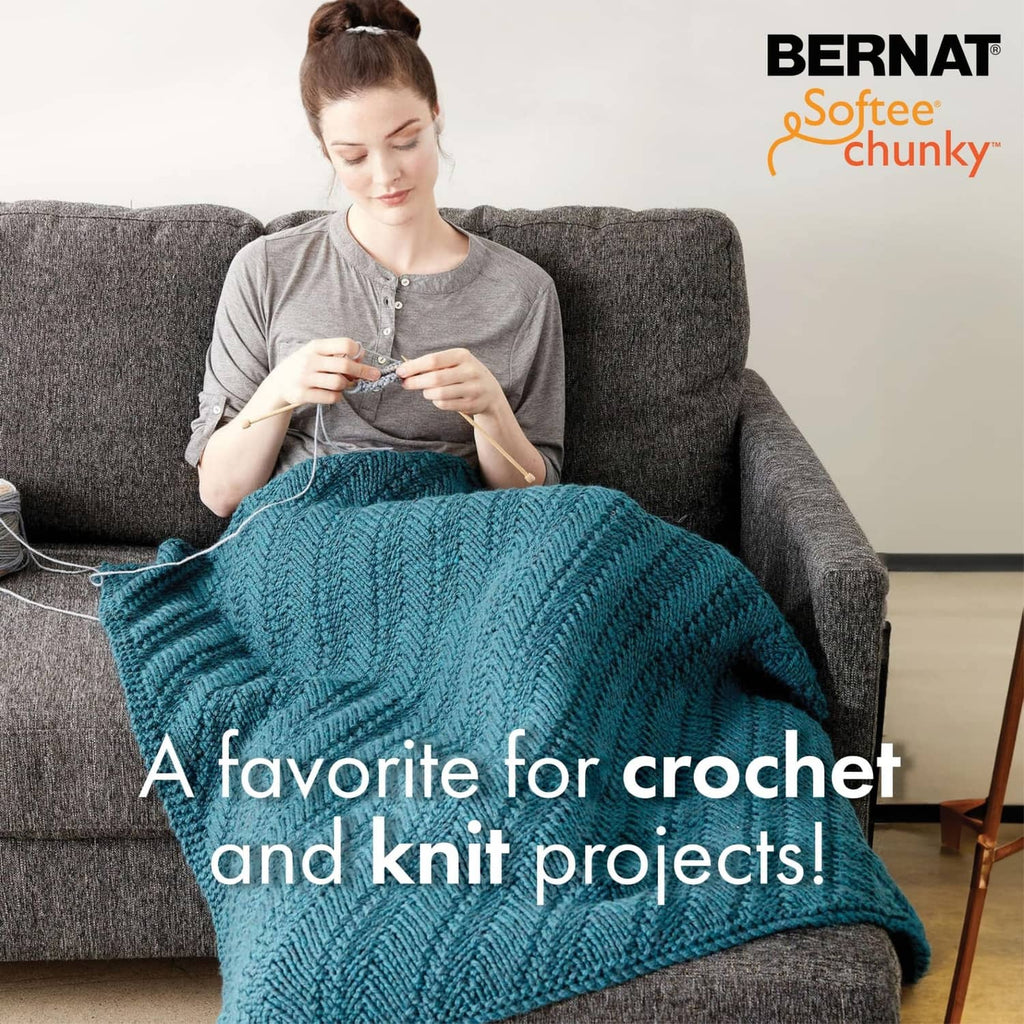 Chunky teal knit blanket with textured stitch pattern draped over a couch