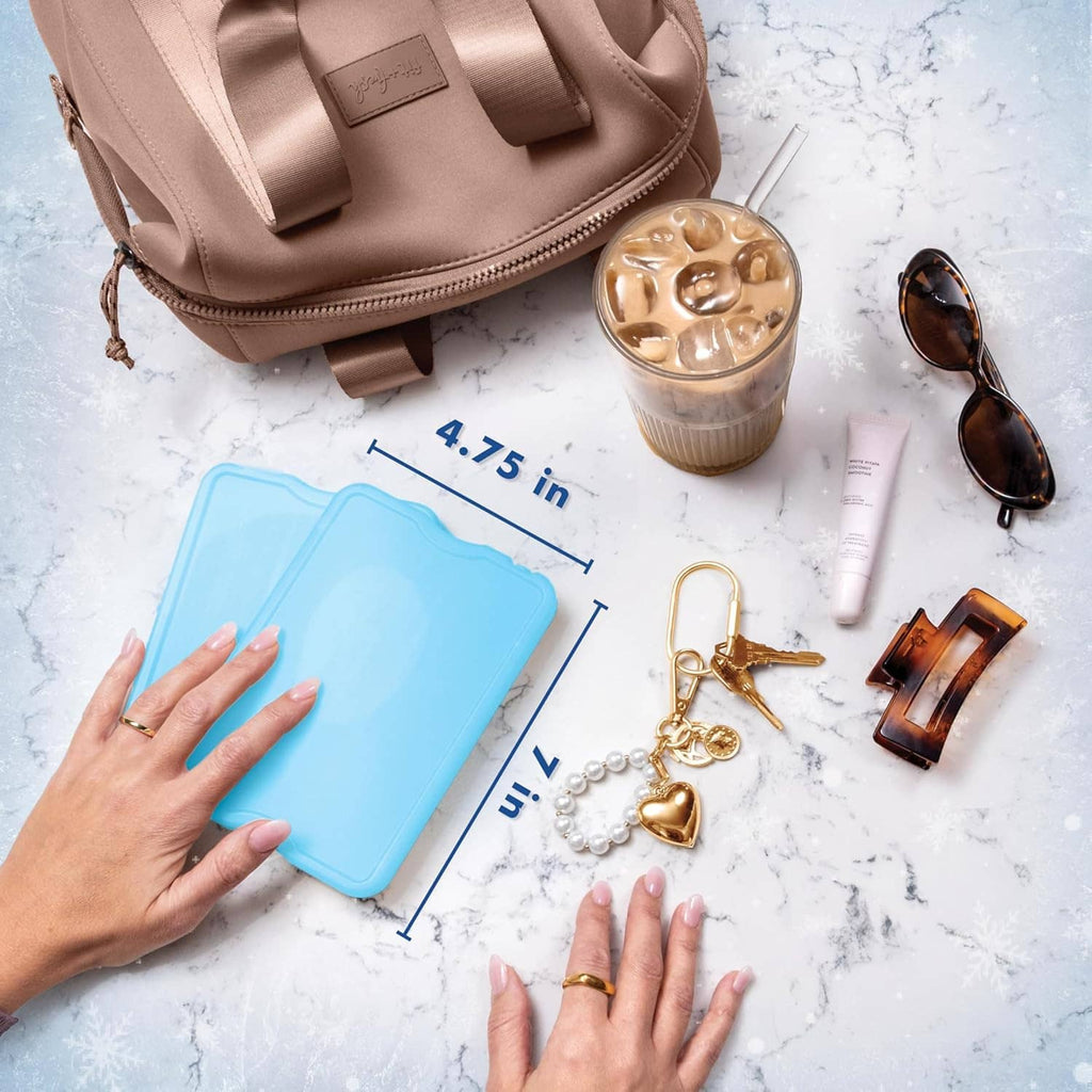 Slim blue reusable ice pack lying on a countertop, shown with size markings