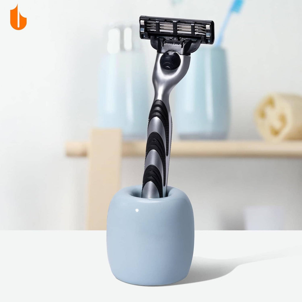 Light blue ceramic toothbrush holder with a standing toothbrush and long handle.