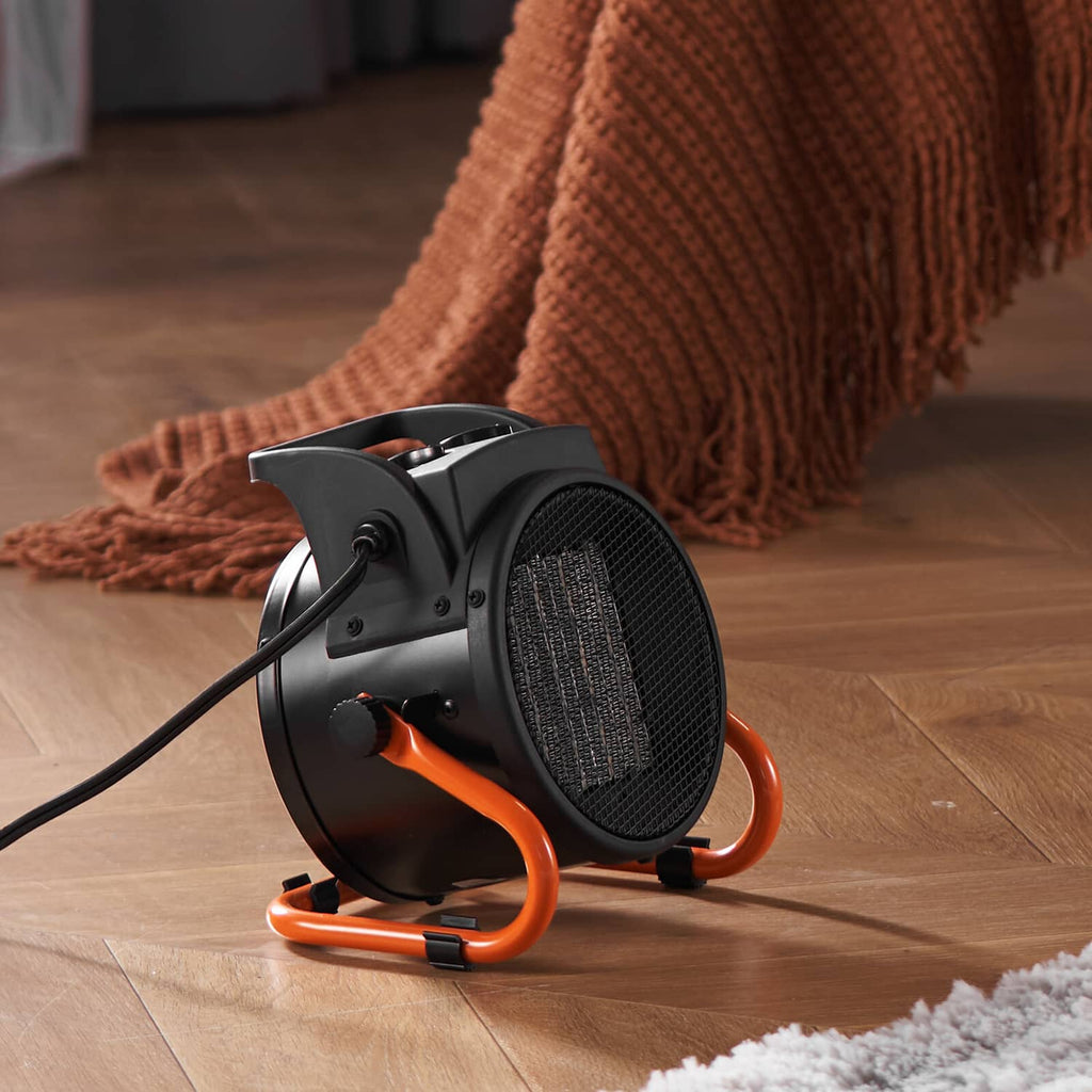 Black VEVOR space heater with front grille and orange legs on wooden floor