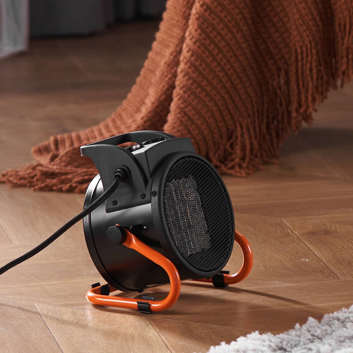 Black VEVOR space heater with front grille and orange legs on wooden floor