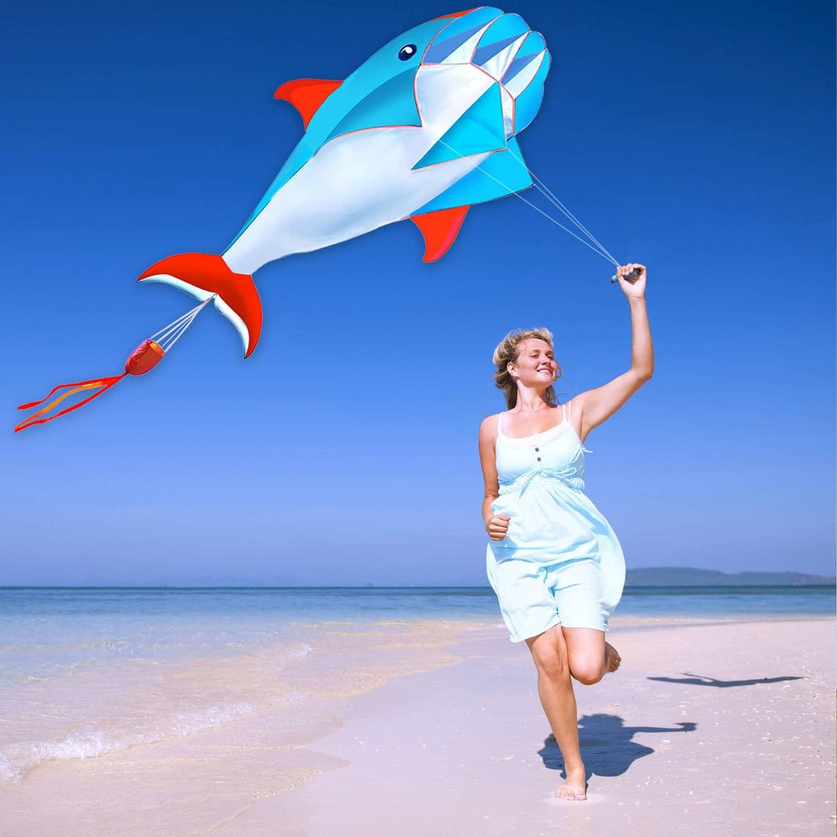 Blue 3D dolphin kite with white belly and red fins, airborne with thin flying line