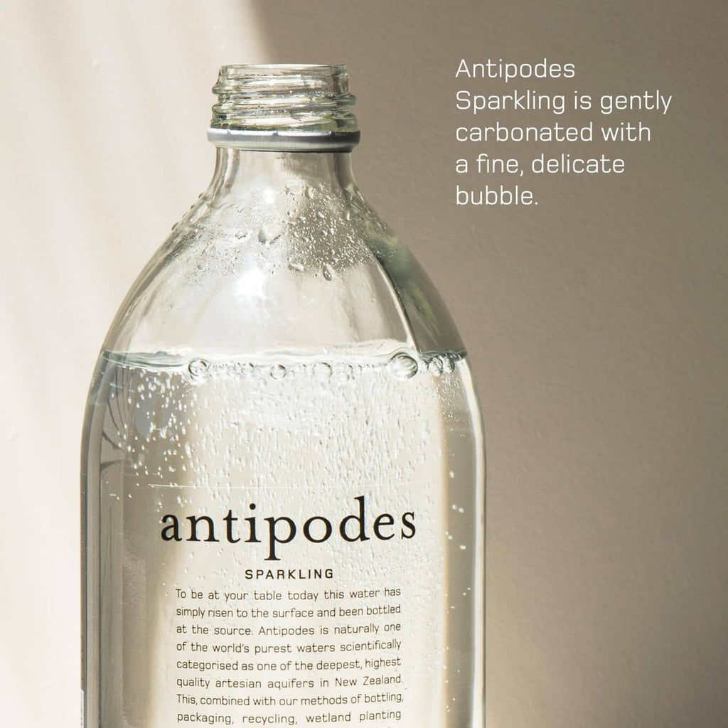 Antipodes sparkling water bottle close-up, clear glass with metal cap