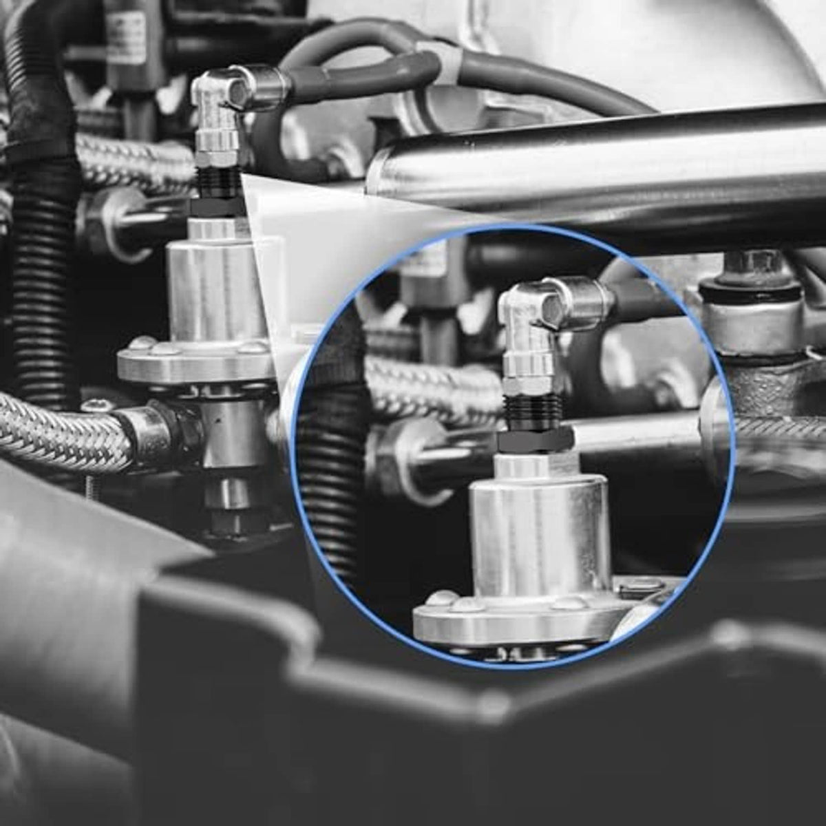 Black NPT fitting adapter connected to hoses and metal fittings, close-up
