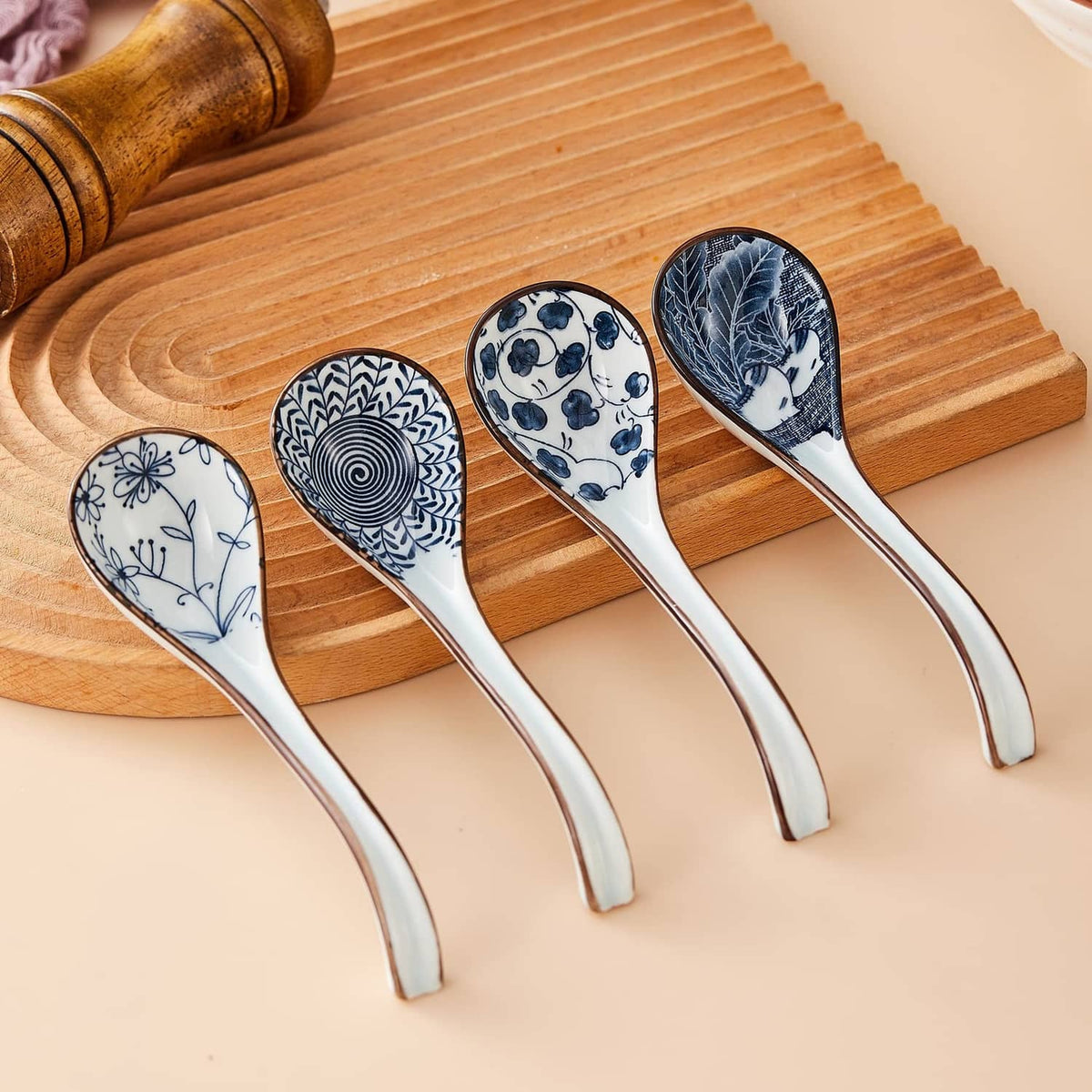 Ceramic Asian soup spoon set of four on wooden board, blue-and-white porcelain head
